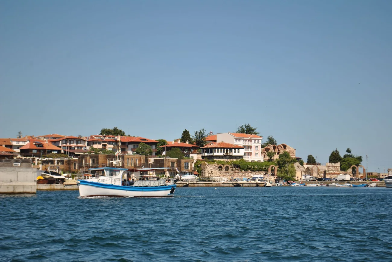 Red-roofed houses of Nessebar on the waterfront with a fishing boat in the foreground