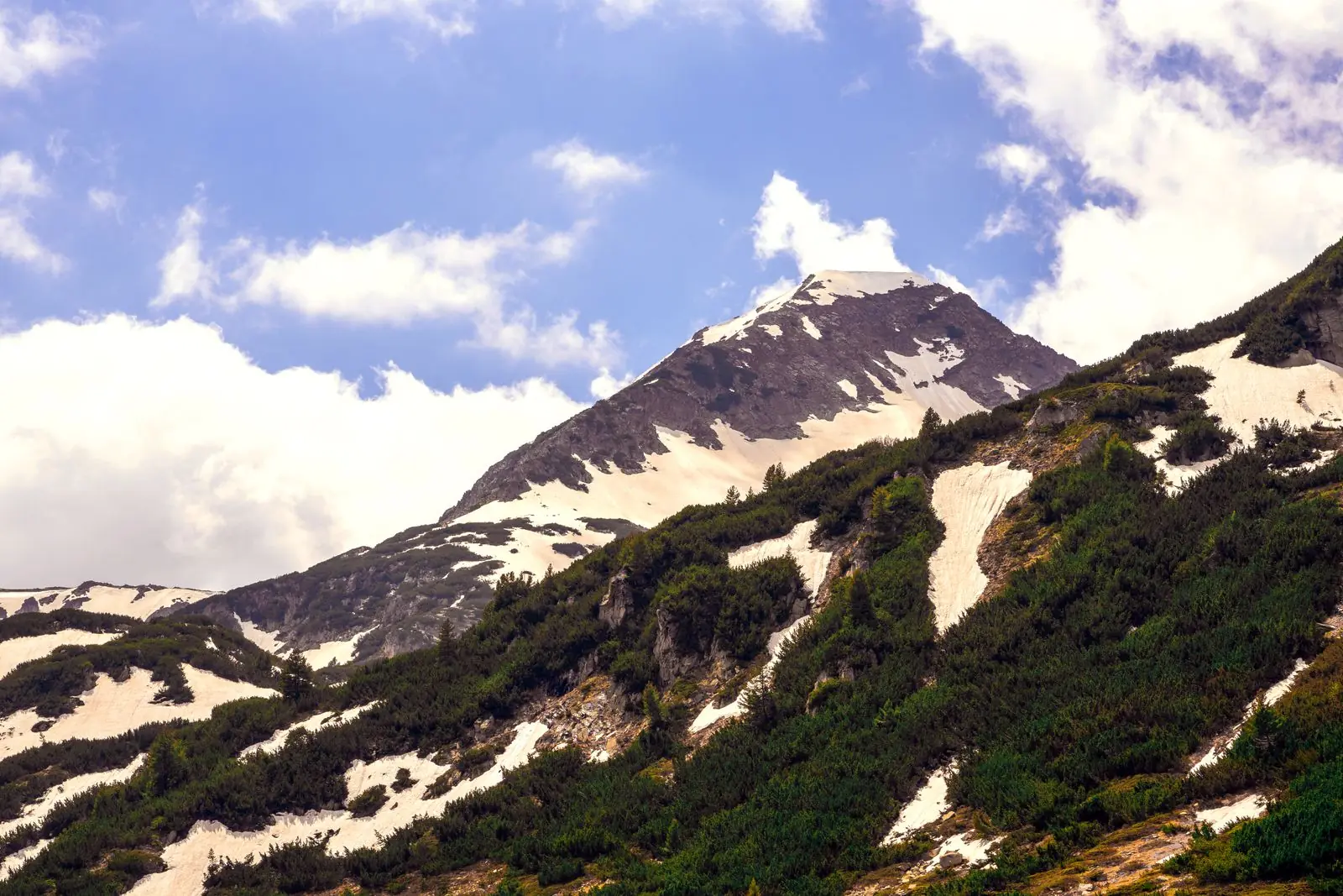Snow-streaked peaks of Pirin National Park under a blue sky
