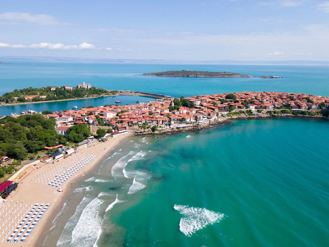 Sozopol old town with red roofs on a peninsula, a sandy beach and turquoise Black Sea water
