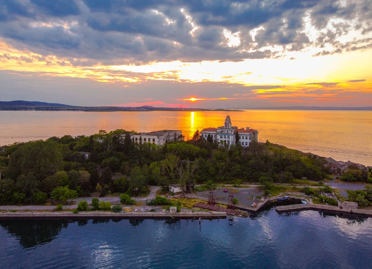 Sunset over the Black Sea near Sozopol with a wooded island and buildings on the shore